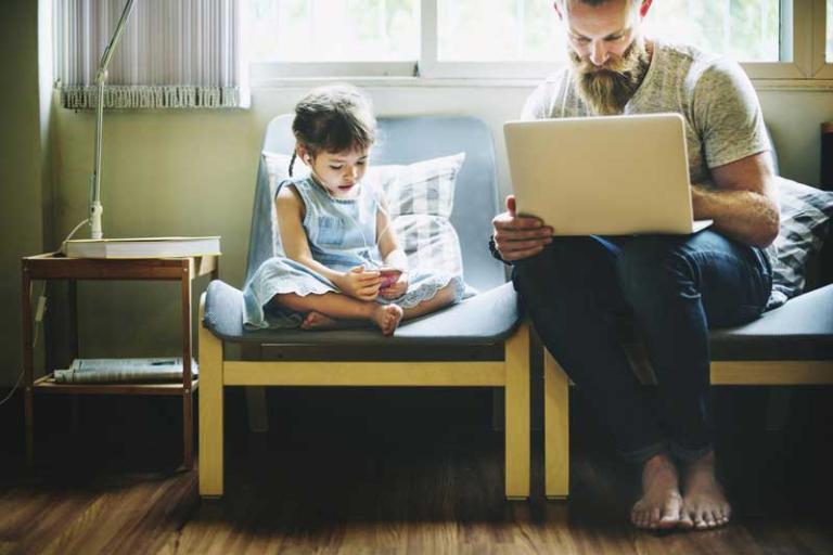 father and daughter on devices